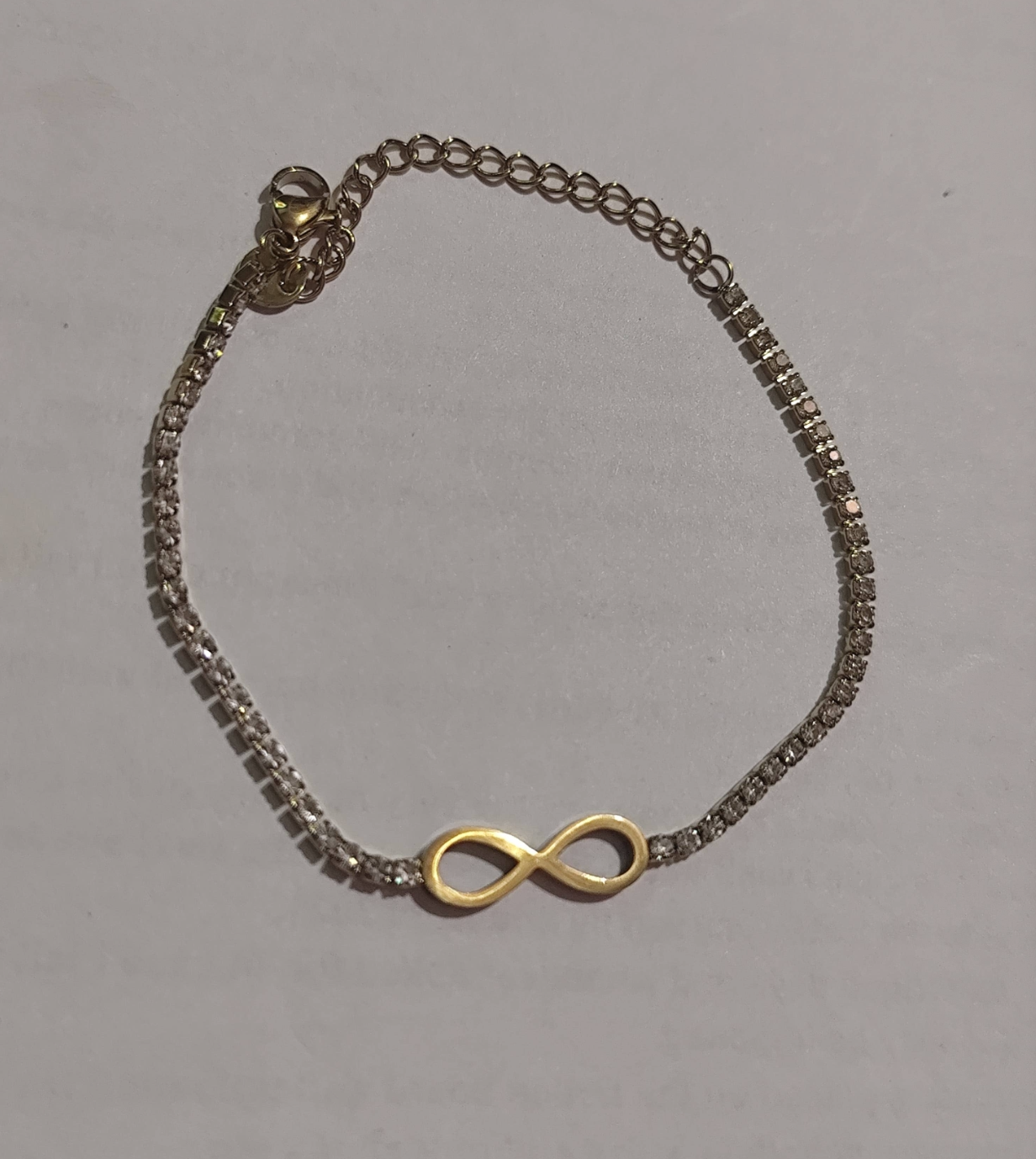 Two-tone cubic zirconia tennis bracelet with infinity symbol charm