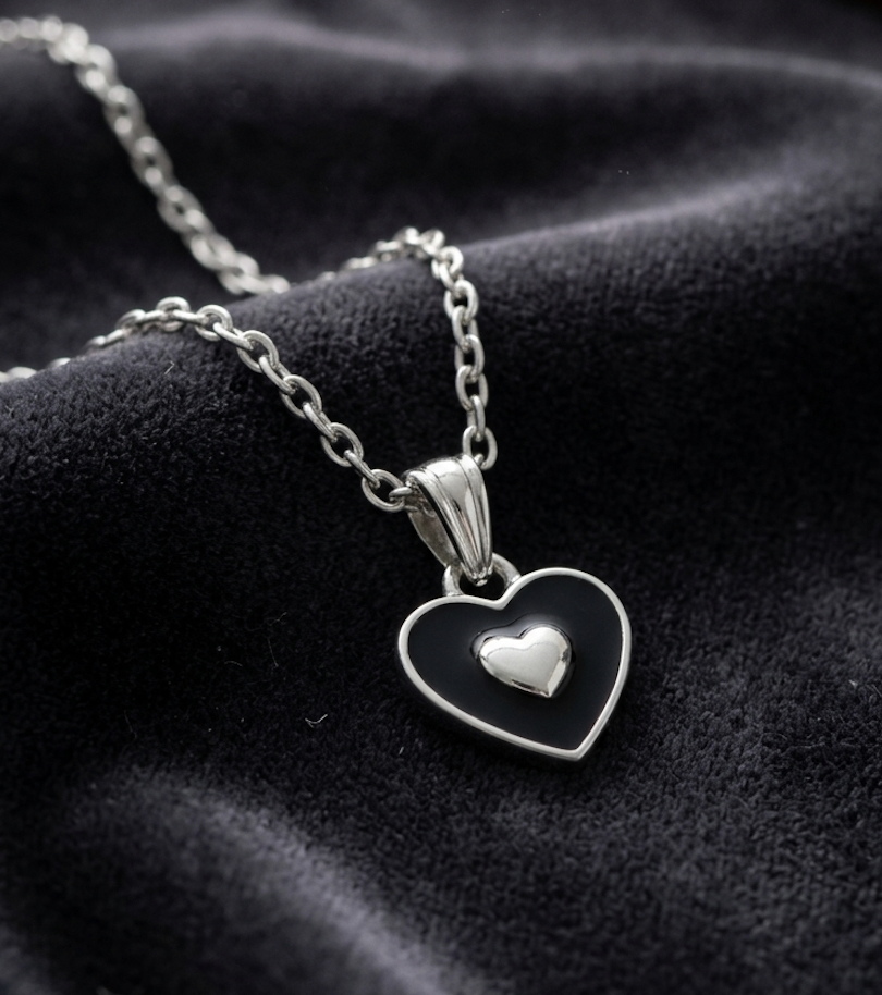 Black enamel heart pendant necklace with silver heart accent on silver chain