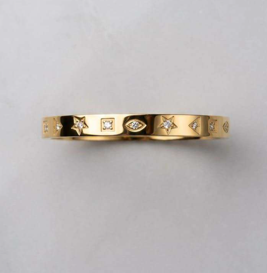 Gold-tone bangle bracelet with star, evil eye, and CZ charm details
