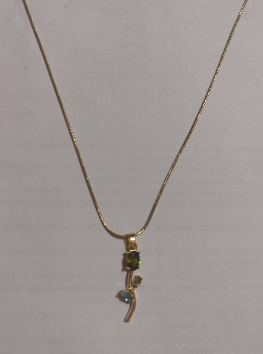 Gold branch pendant necklace with green and blue crystal accents