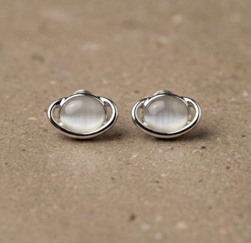 Silver-tone oval stud earrings with cat's-eye moonstone cabochon and swirl ring frame