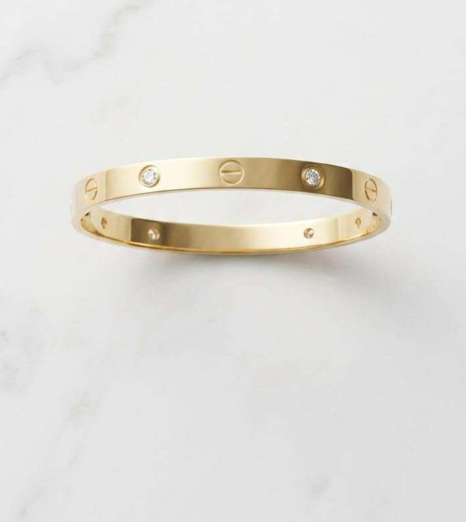 Gold-tone oval bangle bracelet with engraved screw motifs and cubic zirconia accents
