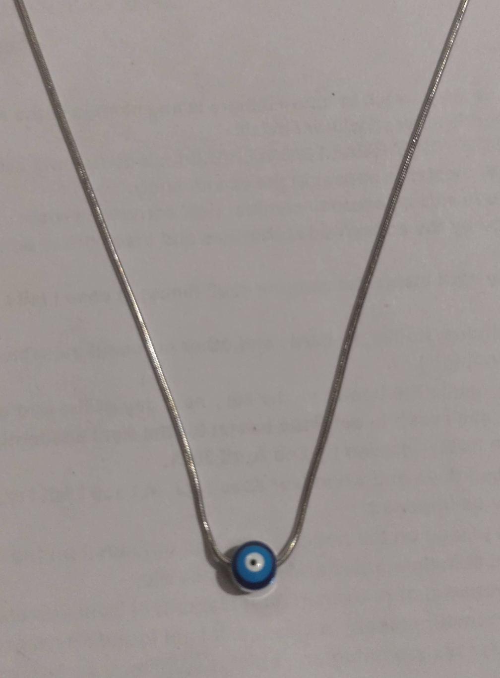 Silver snake chain necklace with single blue evil eye glass bead