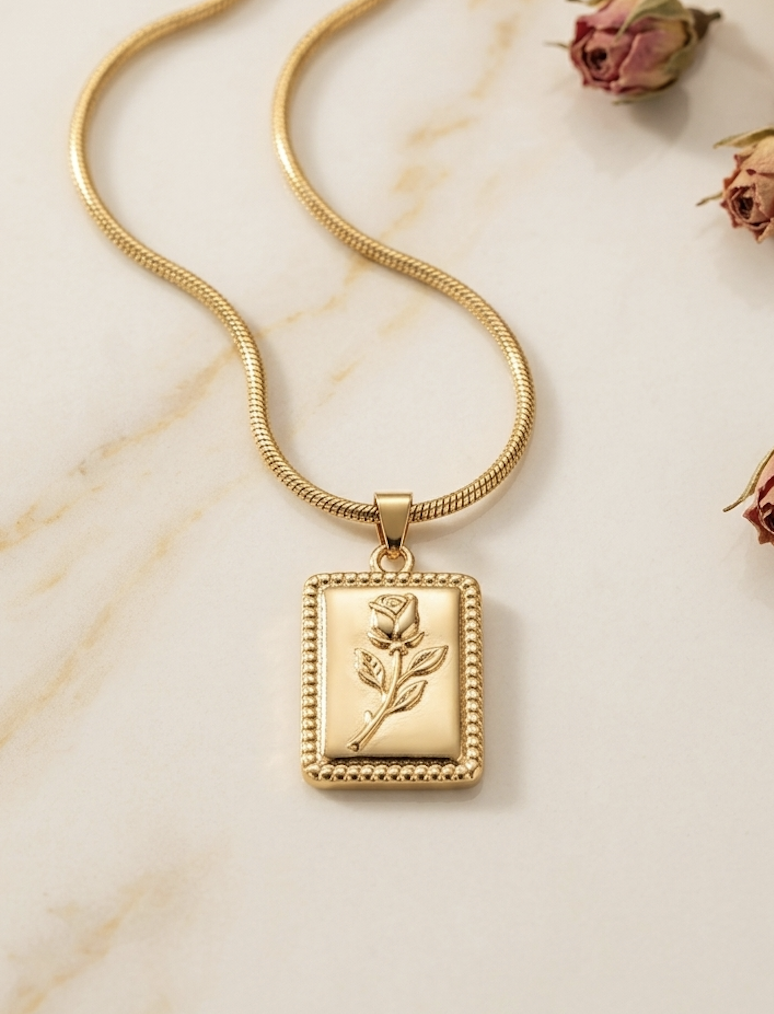 Gold necklace with a rectangular engraved tag pendant on a fine chain