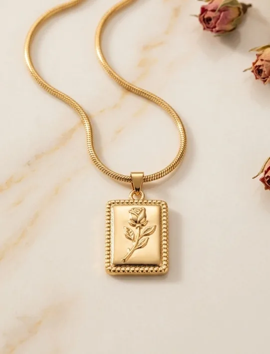 Gold necklace with a rectangular engraved tag pendant on a fine chain
