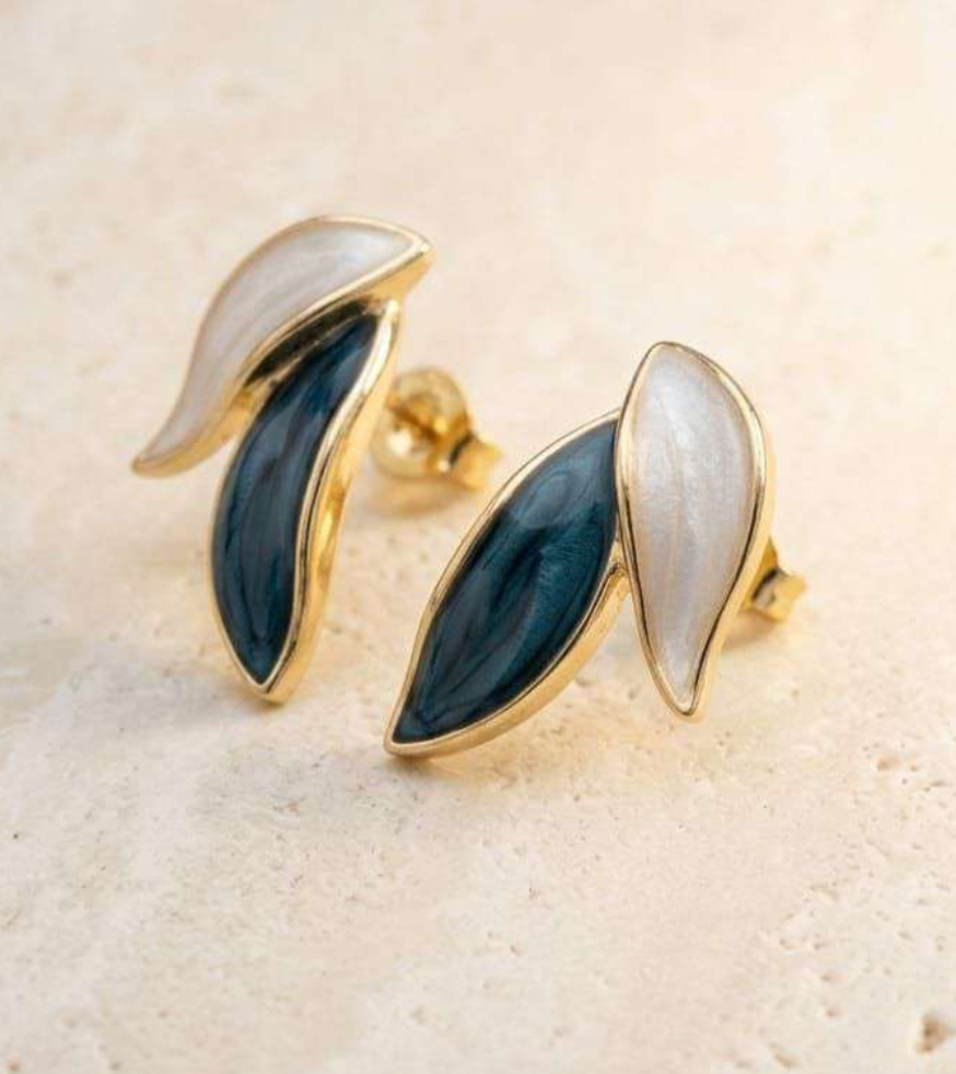 Gold-tone leaf stud earrings with teal and pearl-white enamel petals, angled view