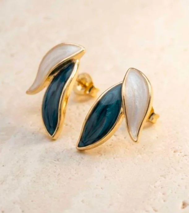 Gold-tone leaf stud earrings with teal and pearl-white enamel petals, angled view