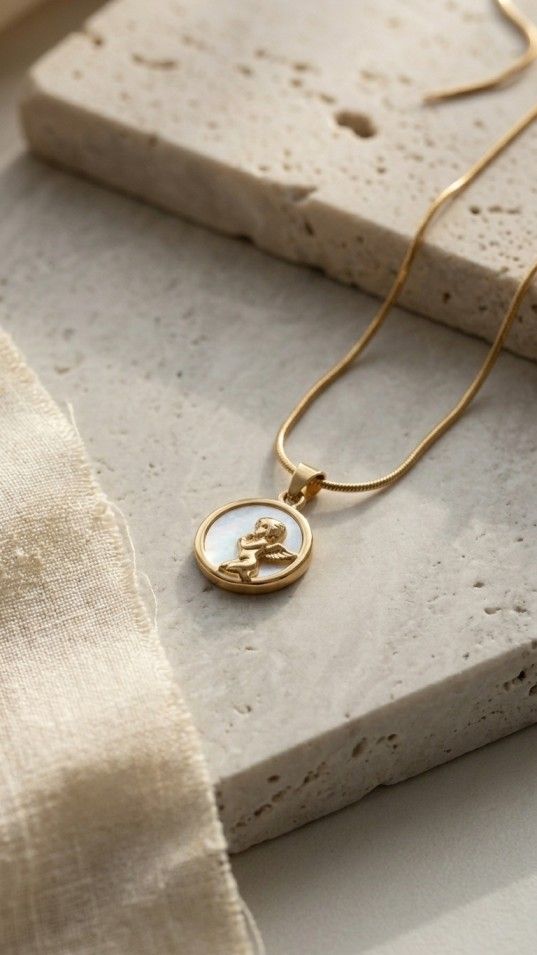 Minimalist gold necklace with round charm pendant on satin background